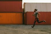 Mann joggtt auf Lagerplatz mit Containern Mann joggtt auf Lagerplatz mit Containern